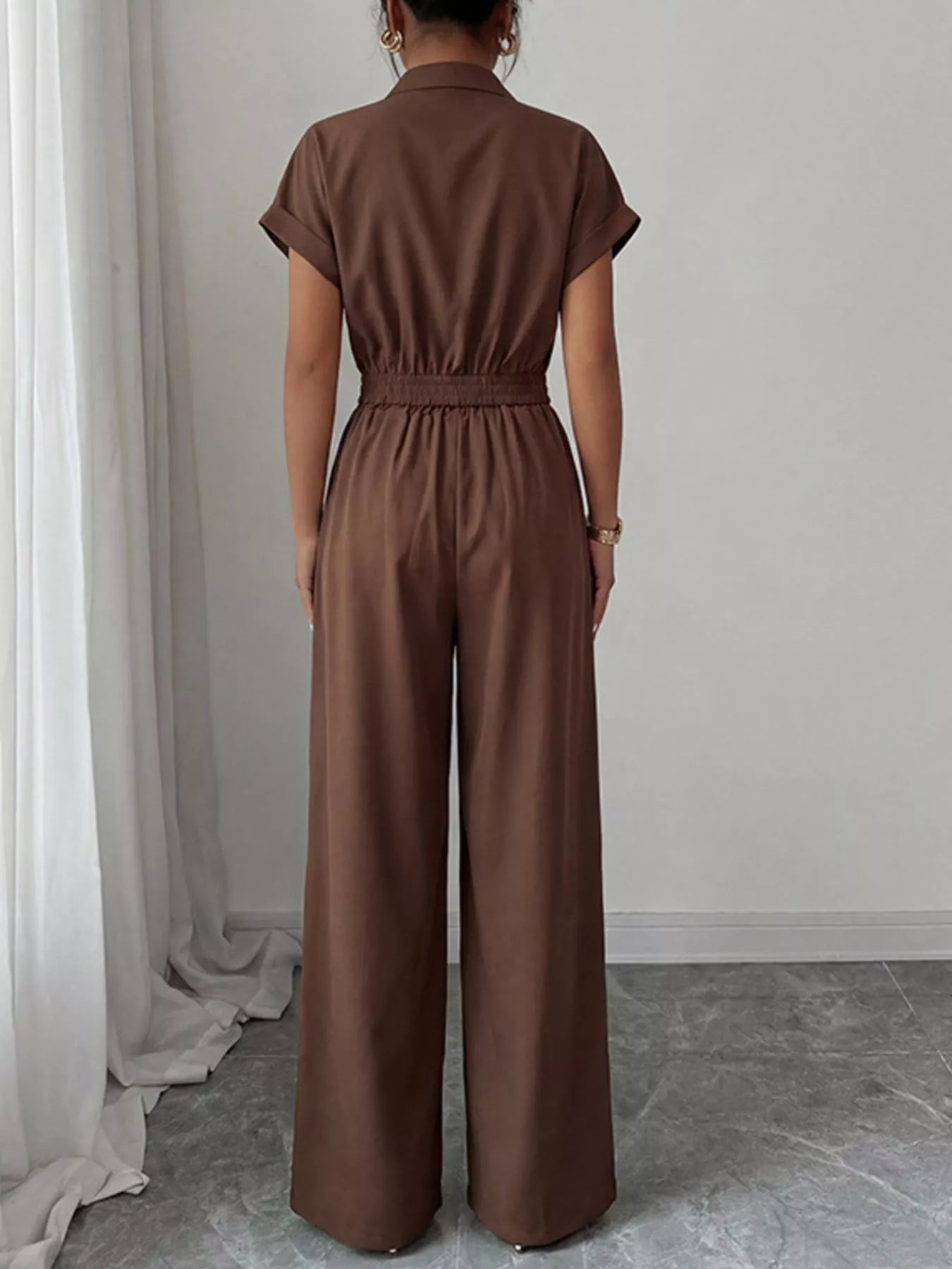 Brown cargo pocket zipper front jumpsuit by Trendsi, featuring a fitted design with functional pockets and front zipper closure.
