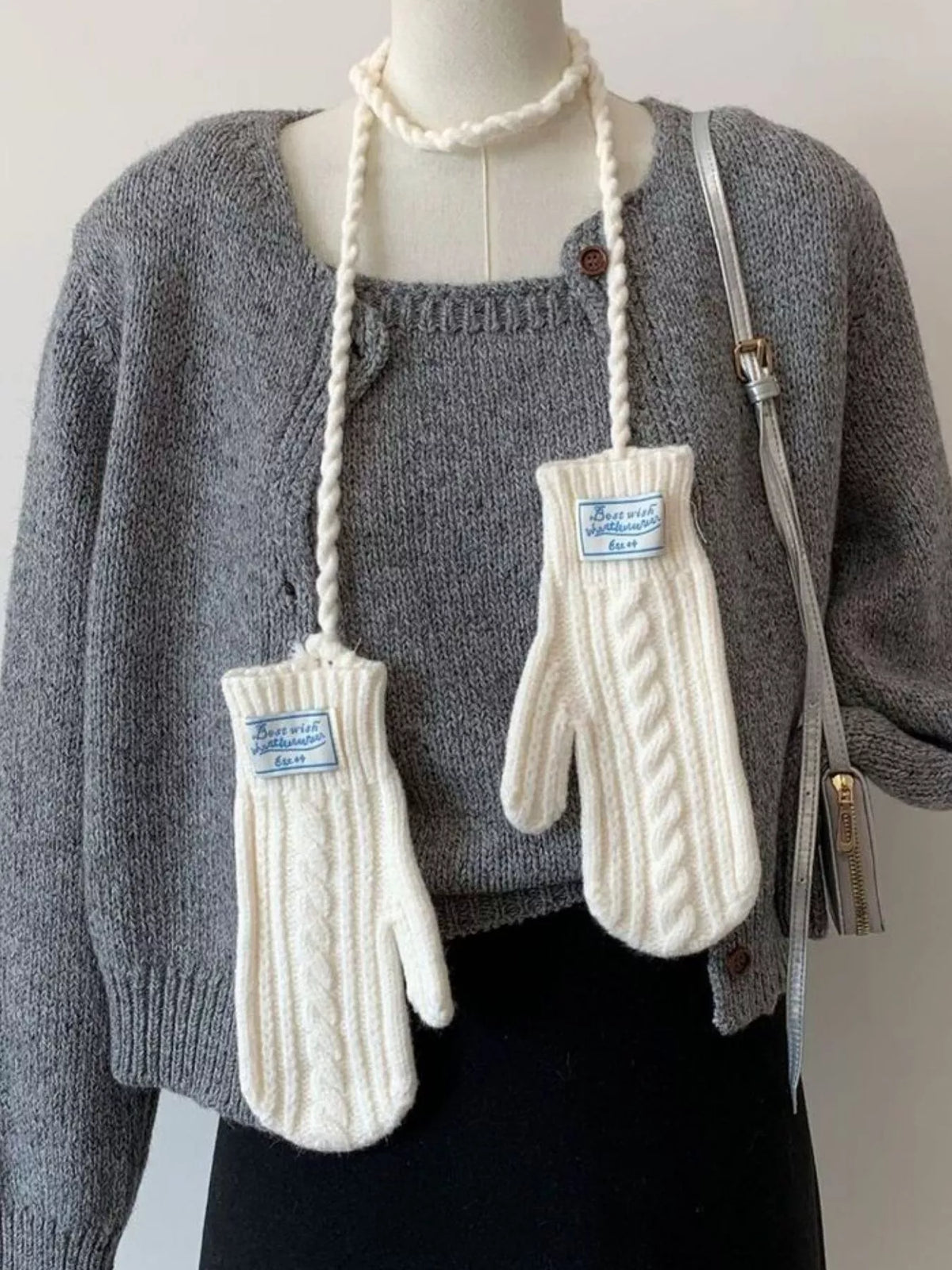 Cable knitted mittens with neck strap from Trendsi, showcasing cozy, textured woolen mittens with attached strap for warmth and style.