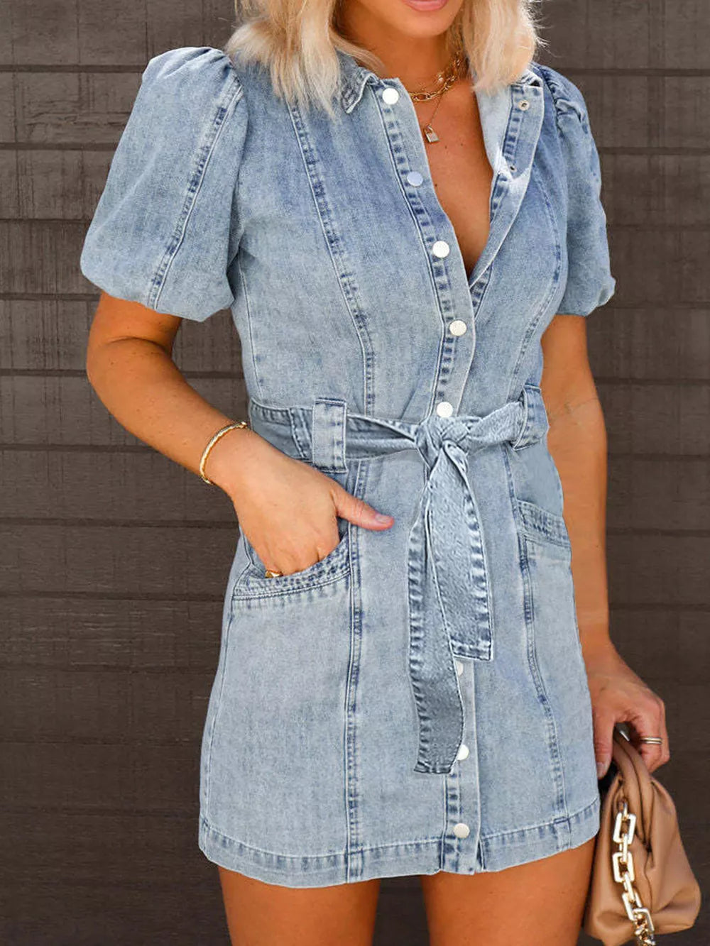 Trendsi puff sleeve button-up mini denim dress hanging on a wooden hanger, showcasing its short length and classic denim fabric.