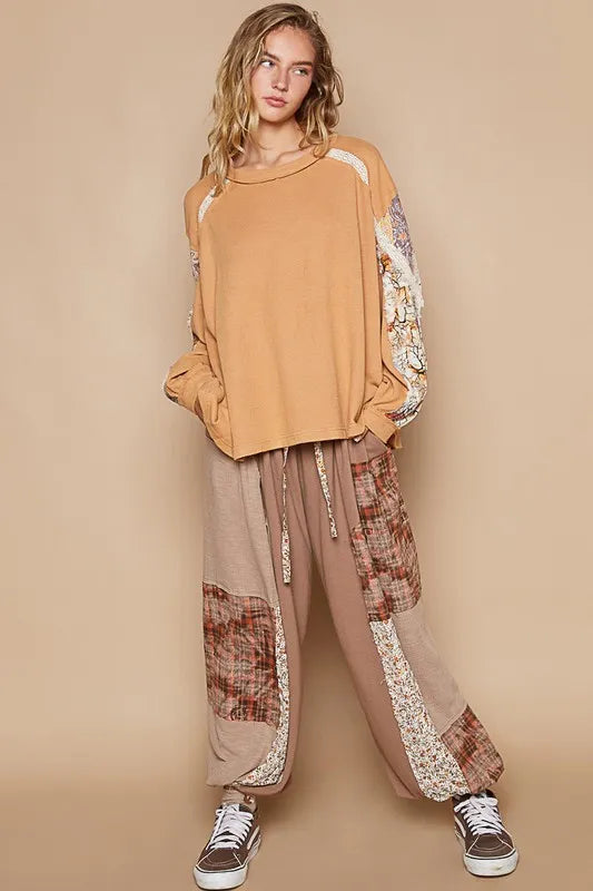 Sherbet-colored waffle-knit lace detail round neck top from Trendsi, featuring a cozy fit and elegant lace accents.