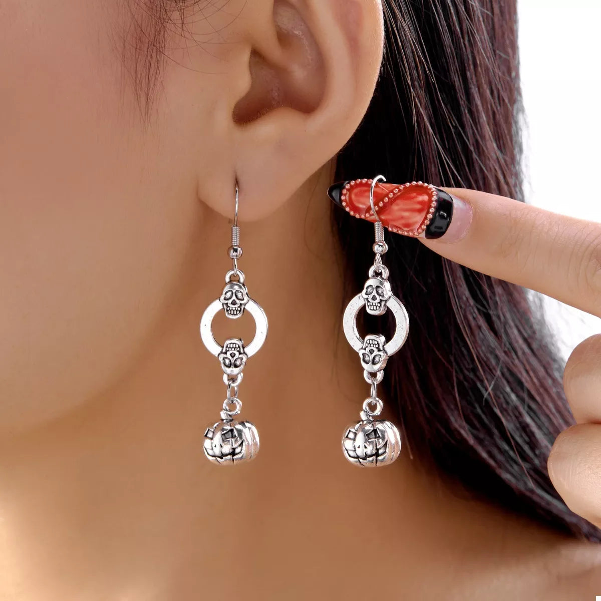 Halloween pumpkin dangle earrings by Trendsi featuring orange pumpkin charms hanging from silver hooks.