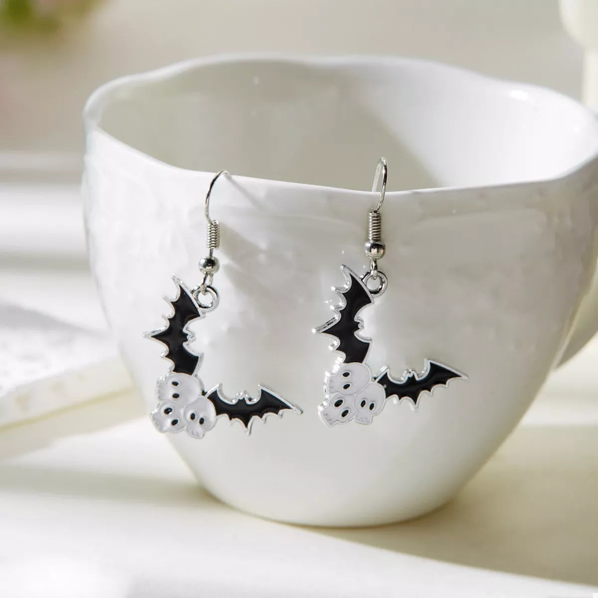 Halloween bat drop earrings by Trendsi featuring black bat-shaped dangle earrings for spooky seasonal style.