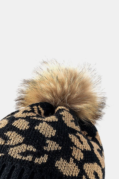 Leopard print pom-pom cuffed beanie by Trendsi featuring a cozy knit design and playful animal print detail.