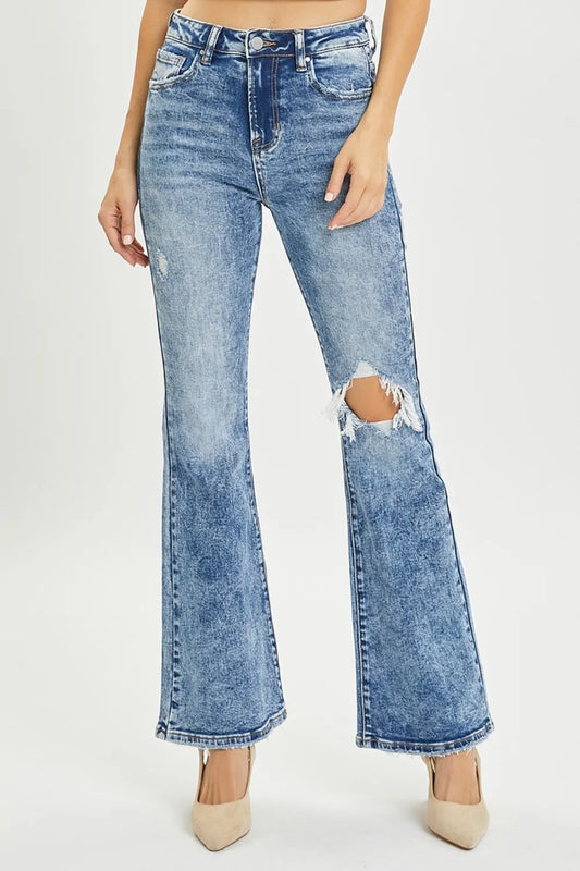 Risen full size high rise distressed flare jeans with ripped details and a fitted waist, displayed on a model against a neutral background.