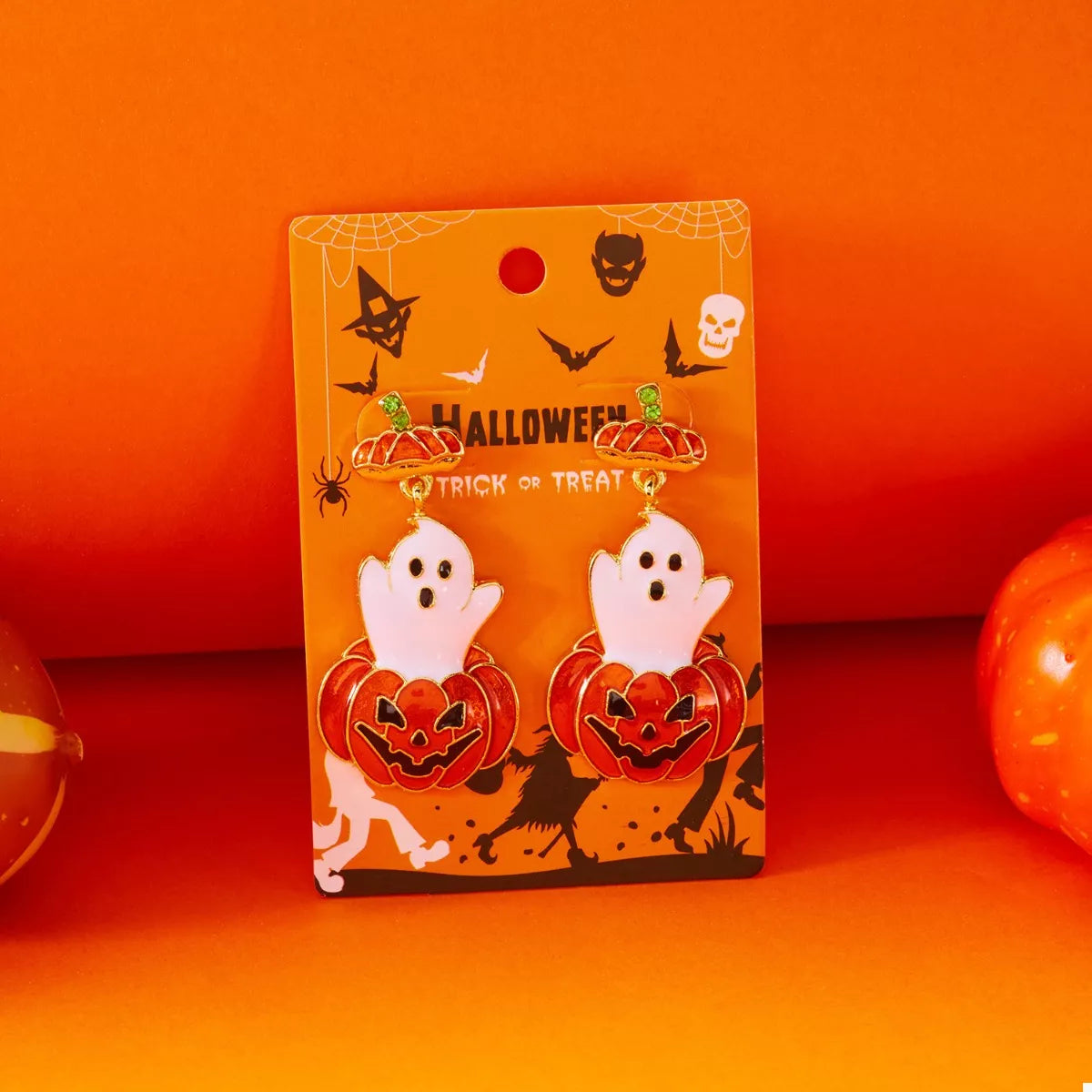 Halloween ghost and pumpkin dangle earrings from Trendsi featuring spooky ghost and pumpkin charms on silver hooks.