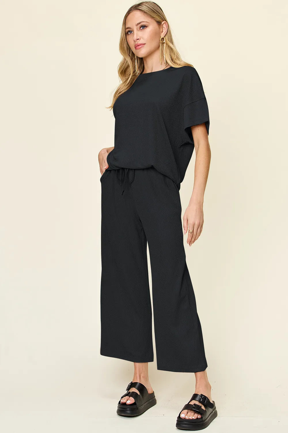 Trendsi Double Take full size textured round neck short sleeve T-shirt paired with wide-leg pants, casual and stylish ensemble.