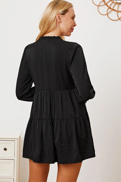 Ruffled button-up long sleeve tiered shirt by Trendsi, featuring layered fabric and detailed ruffle accents in a stylish design.