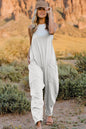 Full-size black V-neck sleeveless jumpsuit with pockets by Trendsi, shown in a front view highlighting its sleek design and fit.