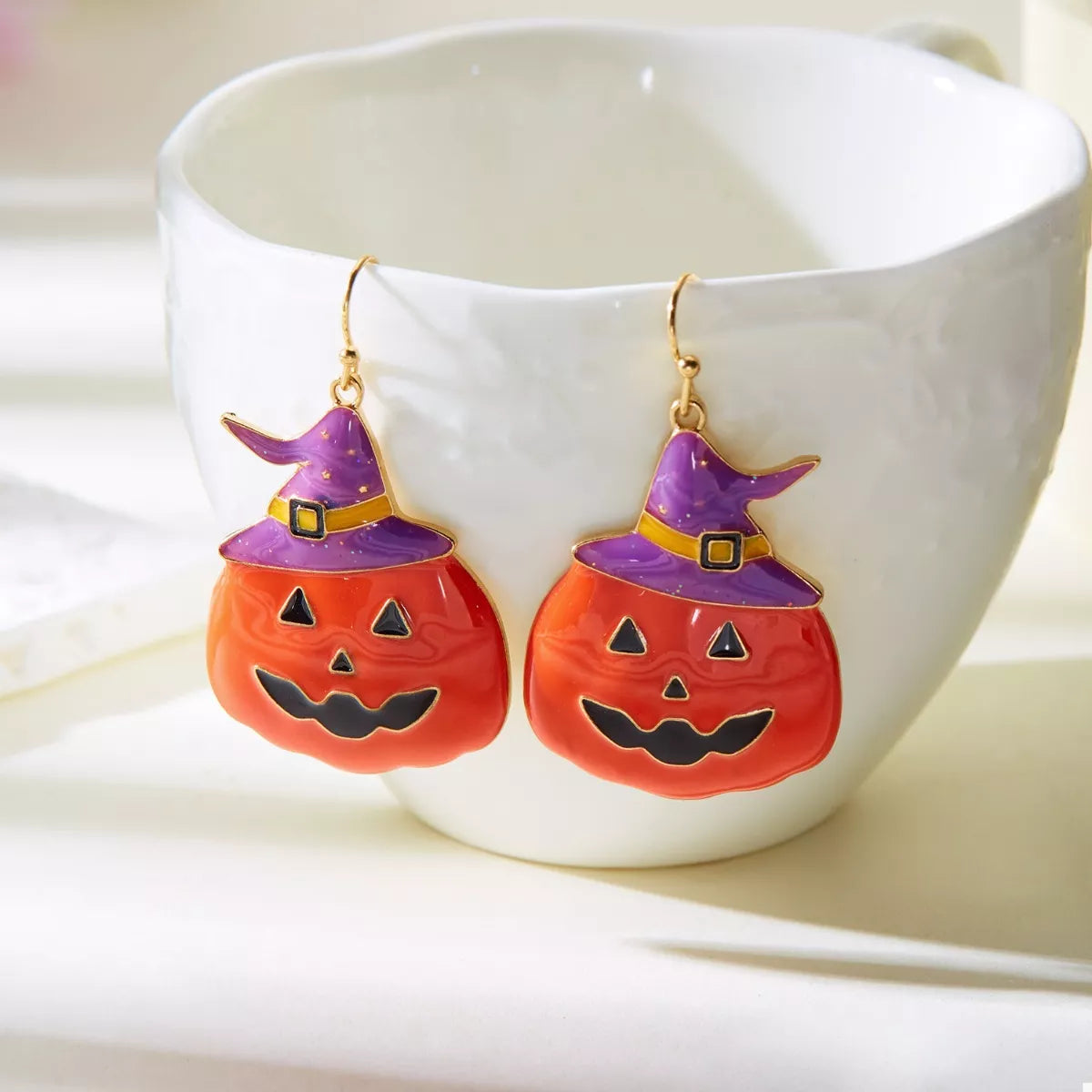 Halloween pumpkin dangle earrings by Trendsi, featuring festive orange pumpkin charms hanging from silver hooks.