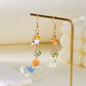 Halloween asymmetrical pumpkin and ghost earrings featuring spooky orange pumpkins and ghost charms, stylish and festive jewelry accessory