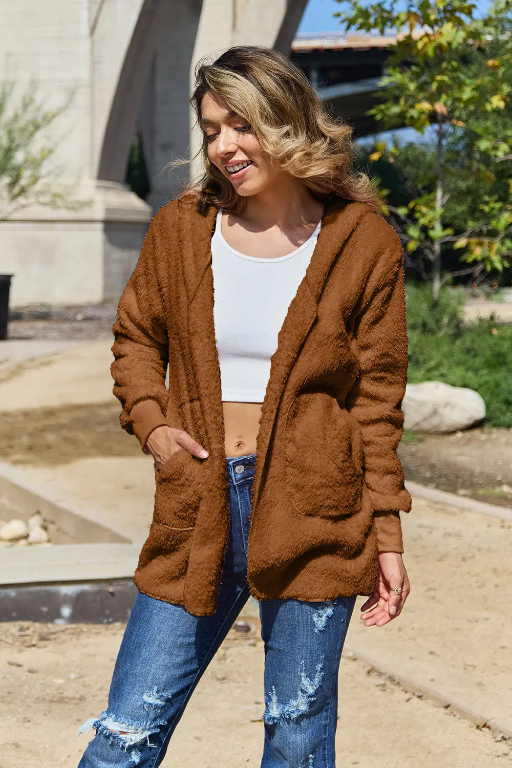 Full size teddy hooded jacket from Trendsi with front pockets, soft plush fabric, and cozy design for cold weather wear.
