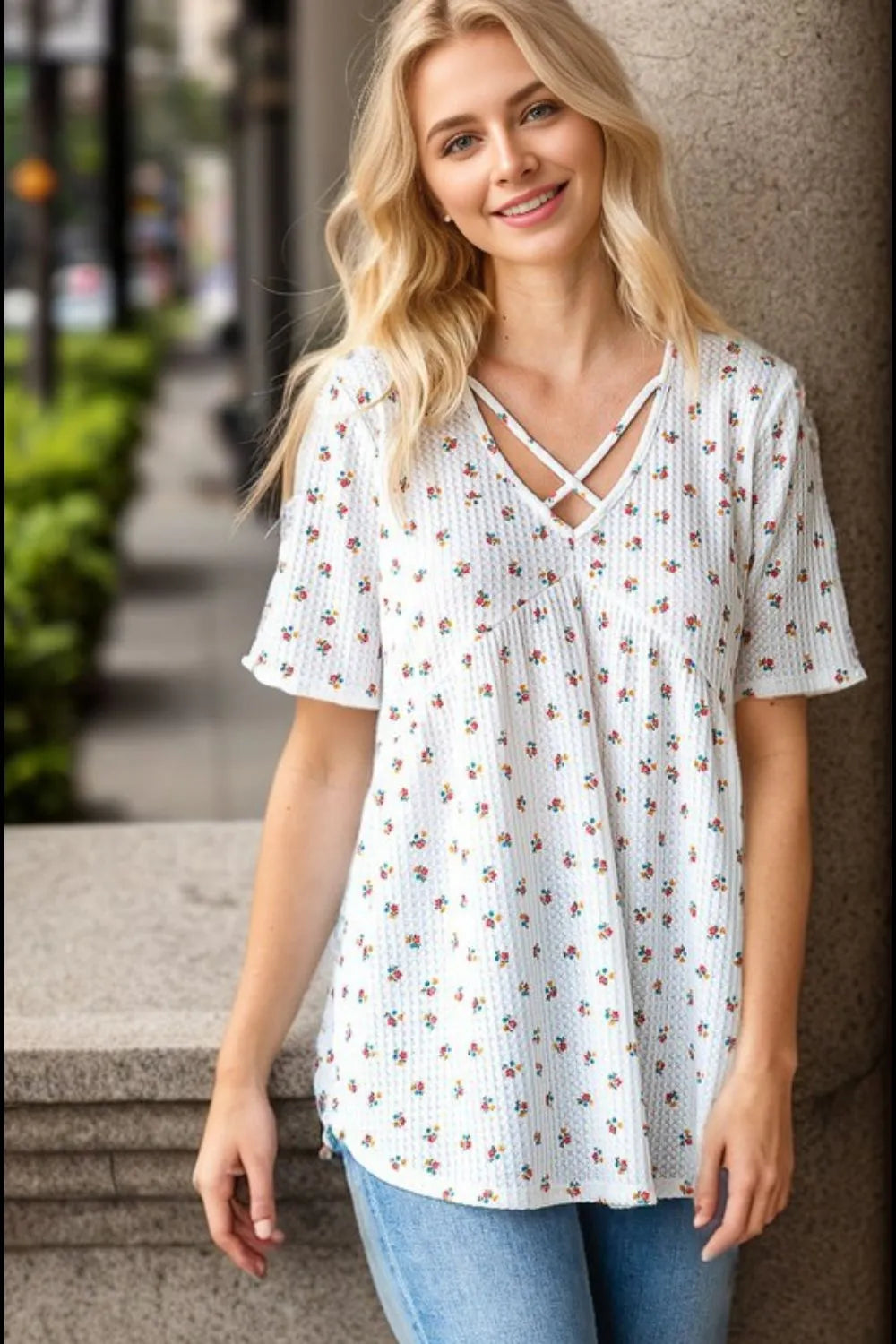 Heimish plus size crisscross ditsy floral babydoll top with ruffled details, worn by a model showcasing its flowy fabric and floral pattern.