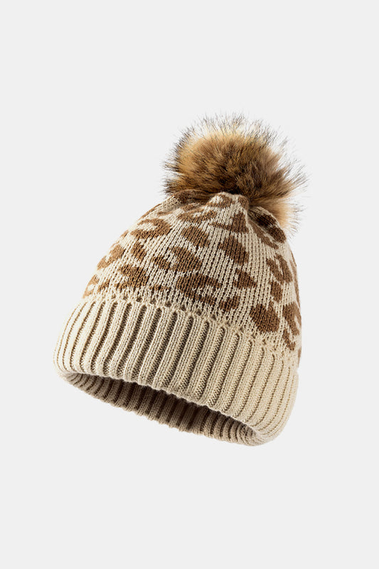 Leopard print pom-pom cuffed beanie by Trendsi featuring a cozy knit design and playful leopard pattern.