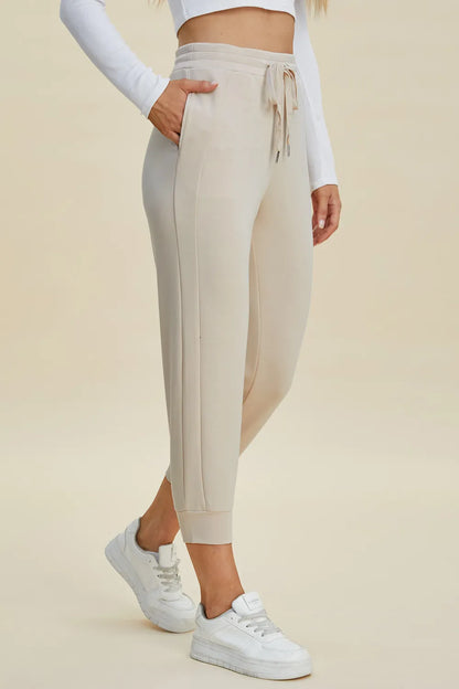 Basic Bae full size air scuba drawstring high waist cropped pants by Trendsi, shown in black with elastic waistband and cropped length.