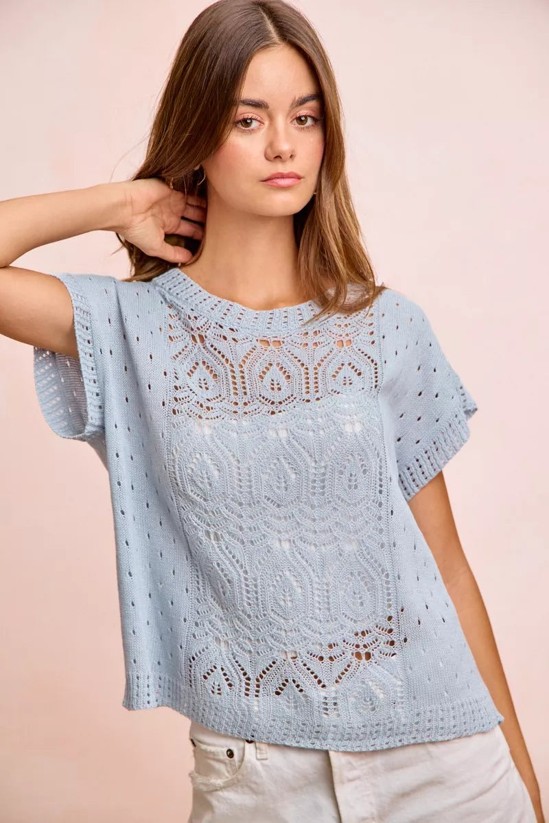 Blue BiBi Washed Eyelet Short Sleeve Knit Top by Trendsi with breathable fabric and eyelet detailing, shown on a model.