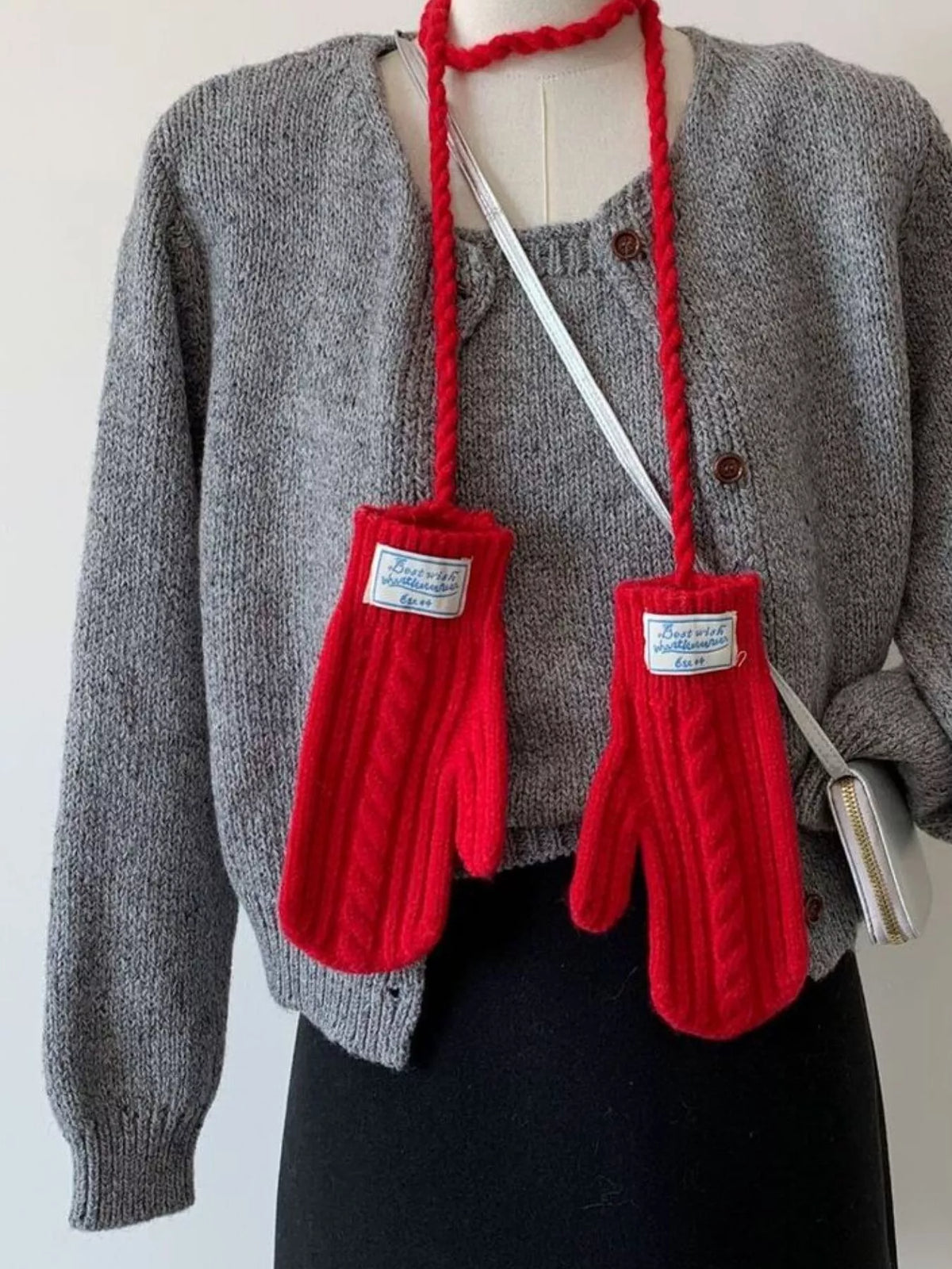 Cable knitted mittens with neck strap from Trendsi, featuring cozy cable knit pattern and adjustable strap for a stylish winter look.