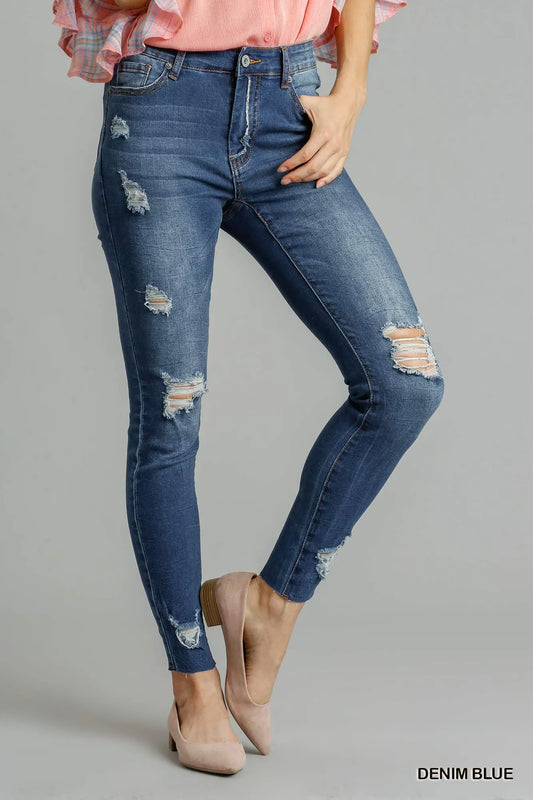Distressed skinny jeans with pockets from Umgee, shown in a close-up image highlighting the denim texture and fit.