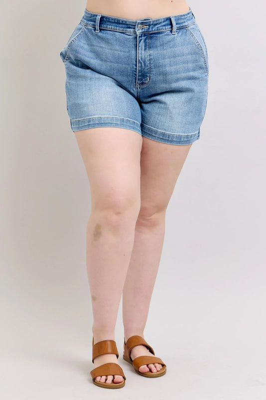 Plus size Judy Blue high rise denim shorts with distressed details, front pockets, and frayed hem on a white background.