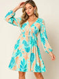 Printed V-neck drawstring dress by Trendsi featuring a full-size design and stylish double take pattern, shown on a mannequin.