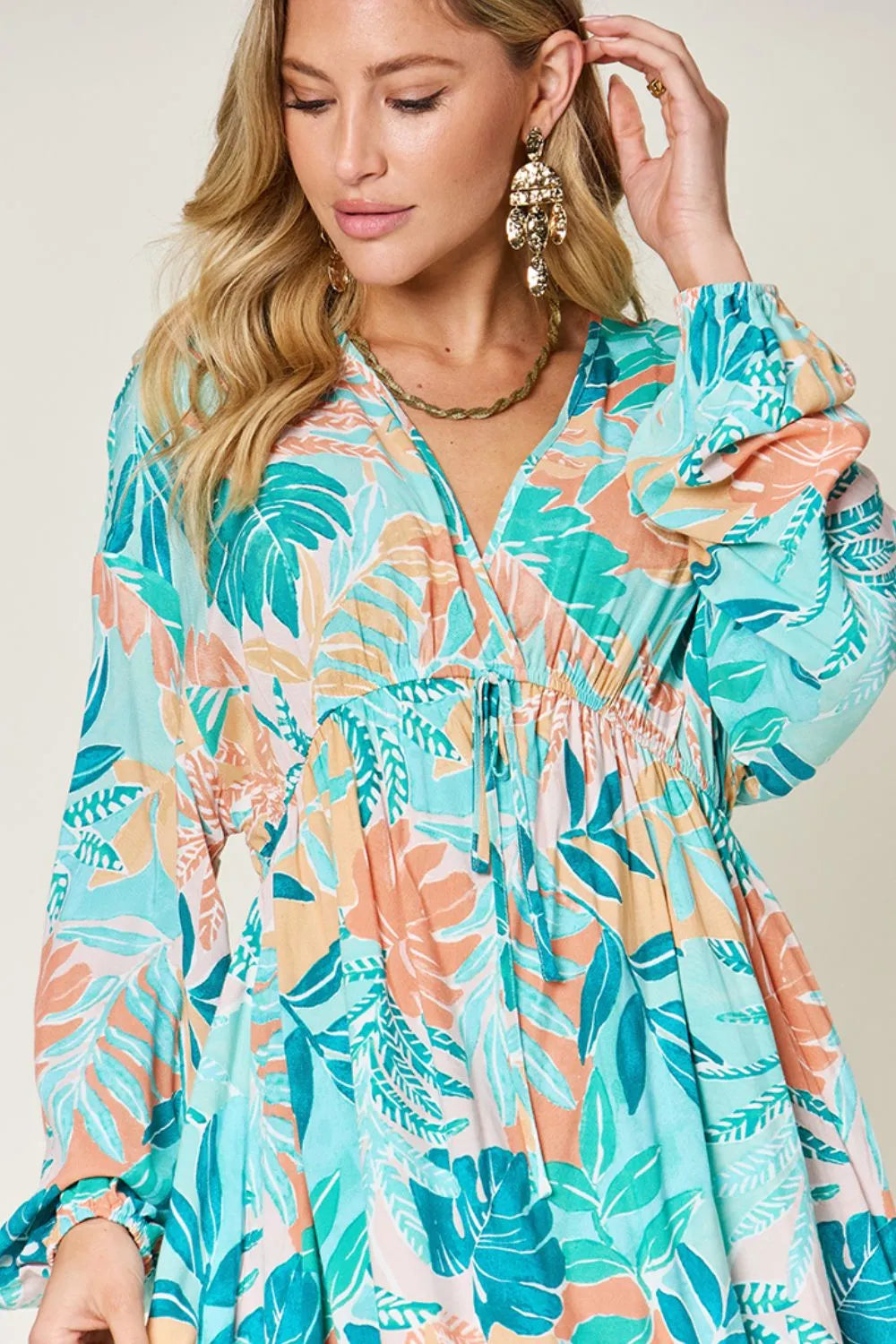 Printed V-neck drawstring dress from Trendsi featuring a full-size, stylish design with a comfortable fit and vibrant pattern.