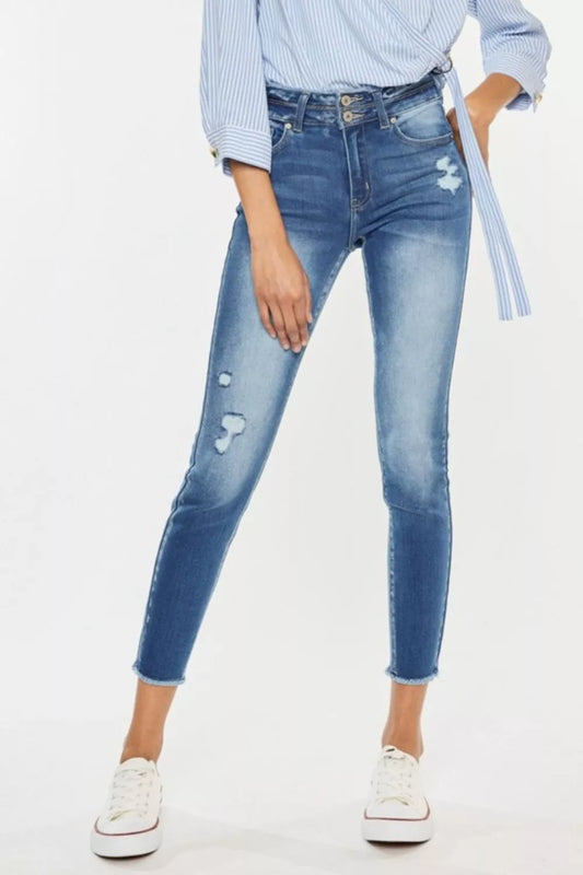 Kancan distressed raw hem high waist jeans with a fitted style and rugged denim look, displayed on a model.