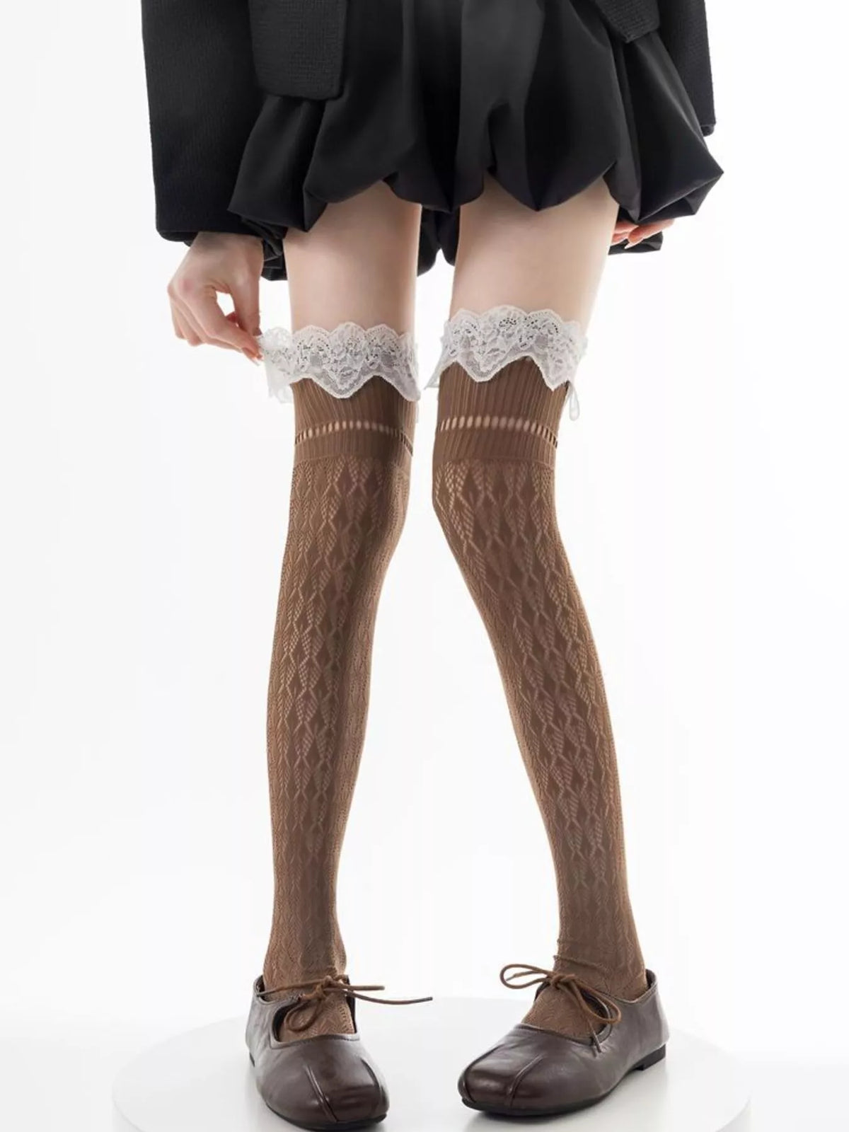 Black lace over-the-knee hollow-out stockings with intricate patterns, featuring a sheer design and a fitted elastic top.
