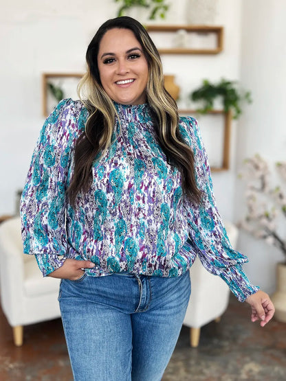 Printed smocked long sleeve blouse from Trendsi, featuring a double take full-size design with gathered fabric and stylish details.