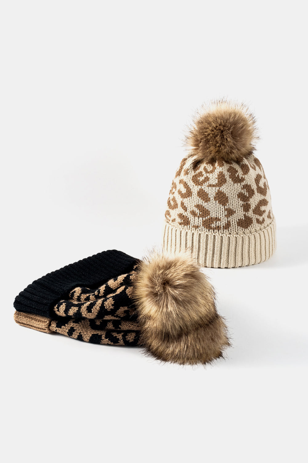 Leopard print pom-pom cuffed beanie by Trendsi featuring a cozy knit design and playful animal print detail.