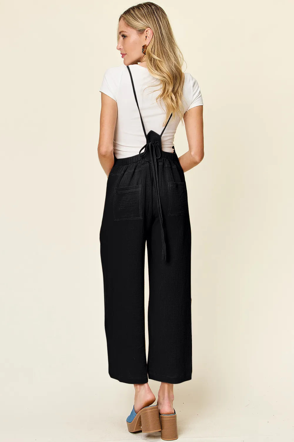 Trendsi Double Take full-size textured sleeveless wide-leg overall displayed on a hanger, showcasing its fabric and design details.