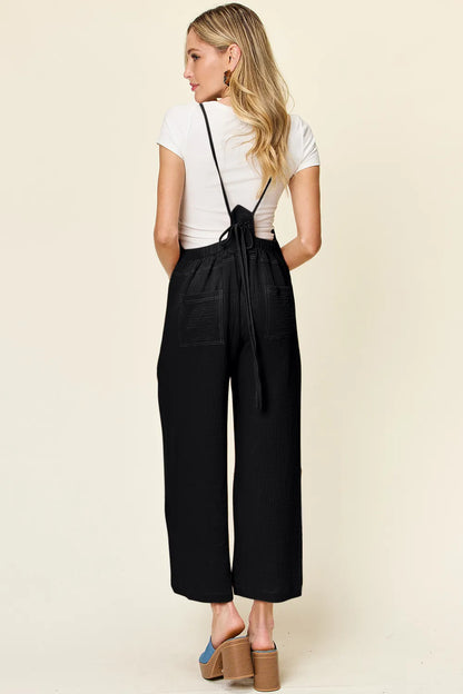 Trendsi Double Take full-size textured sleeveless wide-leg overall displayed on a hanger, showcasing its fabric and design details.