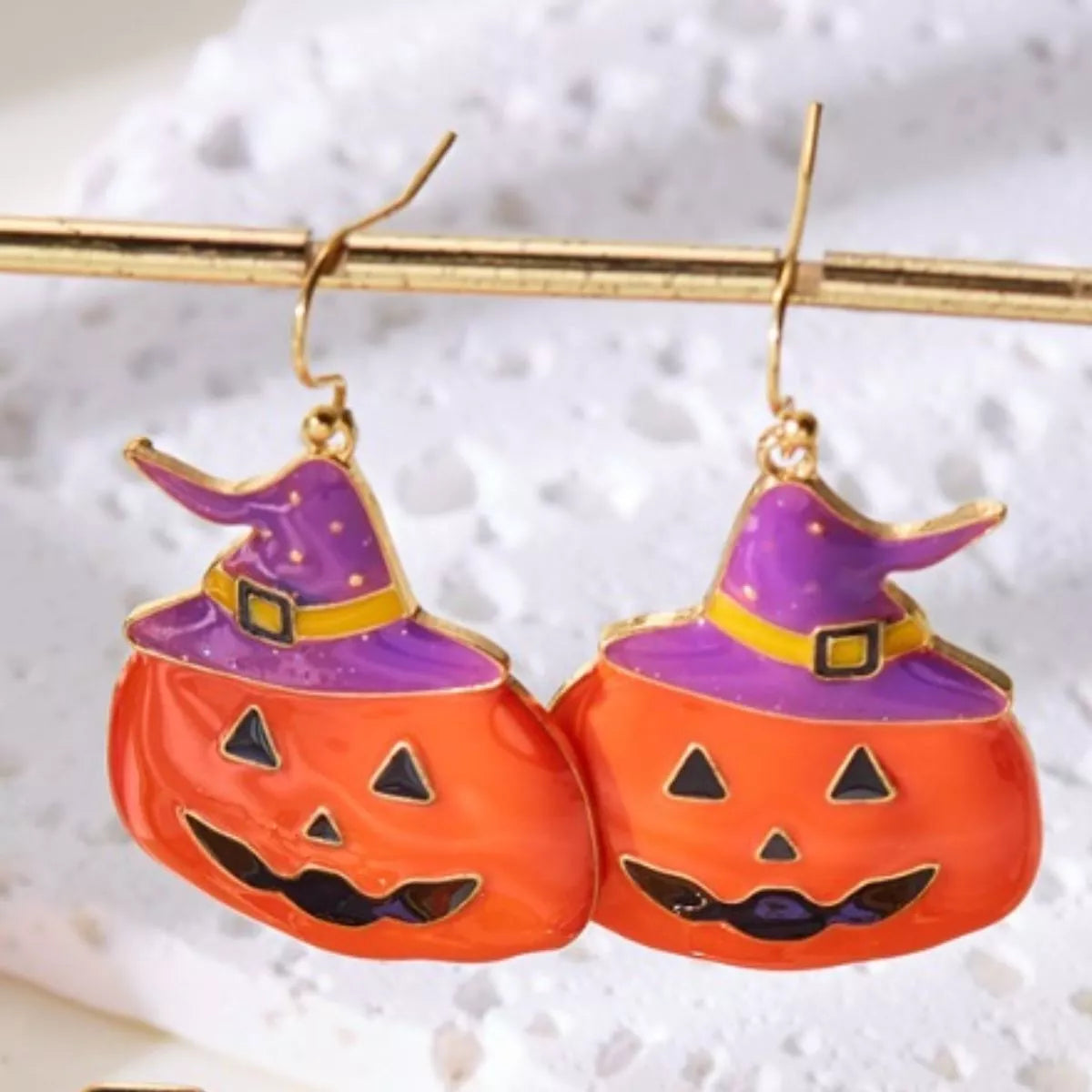 Halloween pumpkin dangle earrings by Trendsi featuring festive orange pumpkin charms hanging from silver hooks.