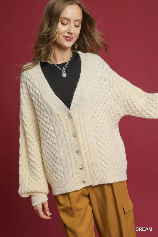 Trendy Umgee cable knit pearl button cardigan in soft material, featuring a classic design with pearl buttons and a cozy fit.