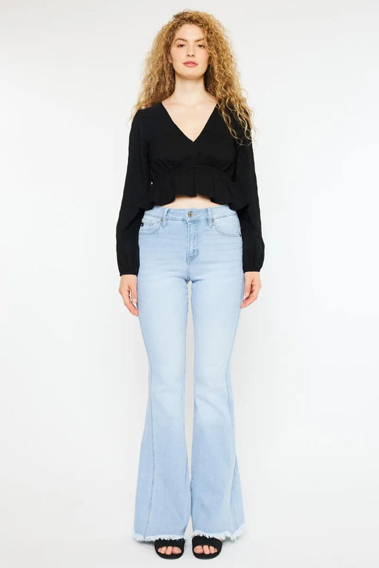 Kancan high rise curvy flare jeans in medium wash with distressed details, styled on a model showcasing fit and flare silhouette.
