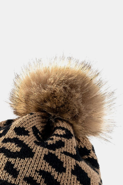 Leopard print pom-pom cuffed beanie by Trendsi, featuring a cozy knit design with playful leopard pattern and fluffy pom-pom detail.