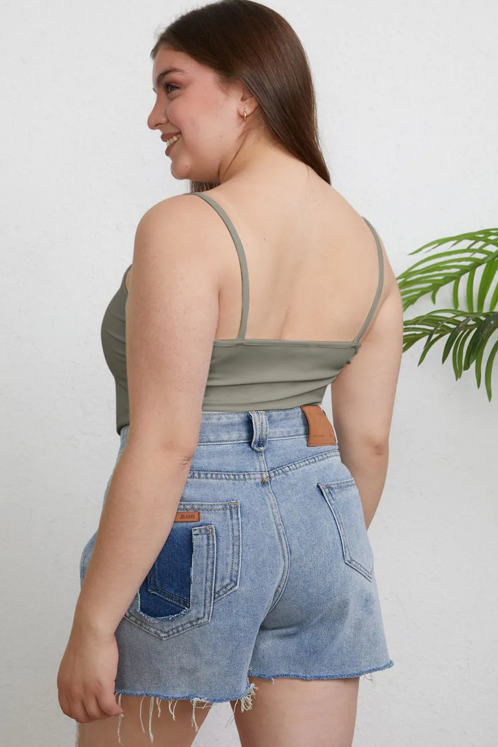Plus size Basic Bae full size round neck slim cami by Trendsi, featuring a close-up of the black sleeveless top.
