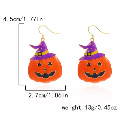Halloween pumpkin dangle earrings by Trendsi featuring orange pumpkin charms hanging from silver hooks.