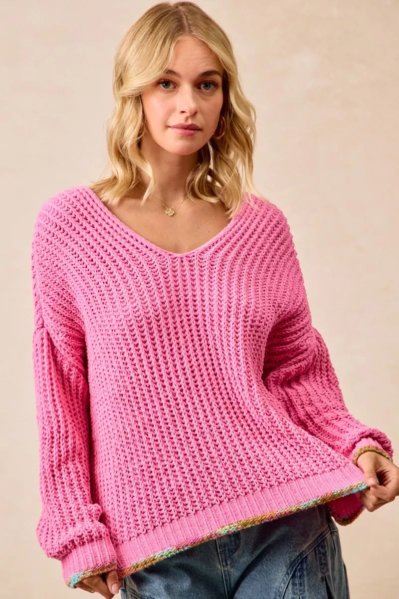 BiBi V-Neck Sweater by Trendsi featuring a colorful trim and soft knit fabric, shown on a model in a casual fashion setting.