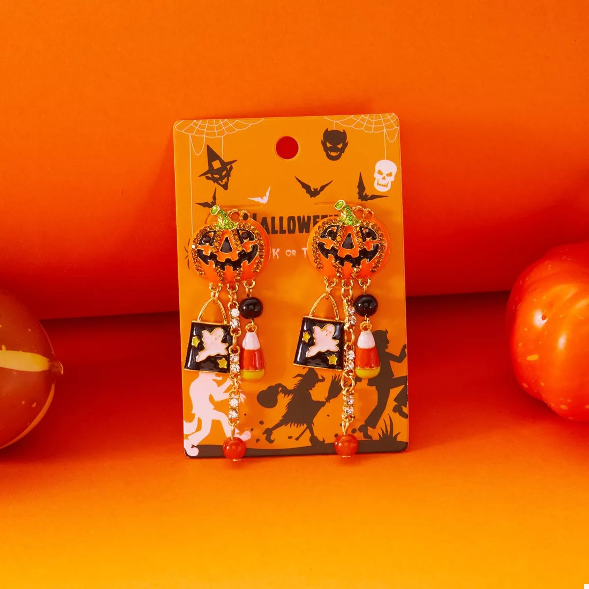 Halloween pumpkin drop earrings featuring orange pumpkin charms with black accents, trendy jewelry by Trendsi.