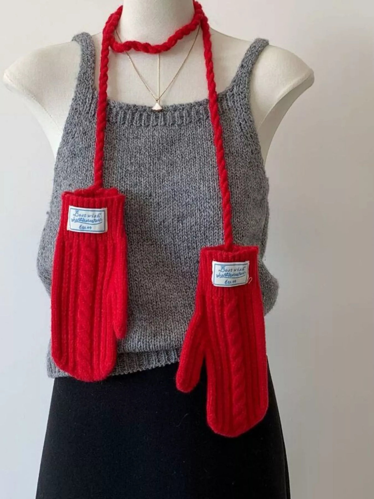 Cable knitted mittens with neck strap from Trendsi, featuring a cozy textured design and adjustable strap for warmth and style.