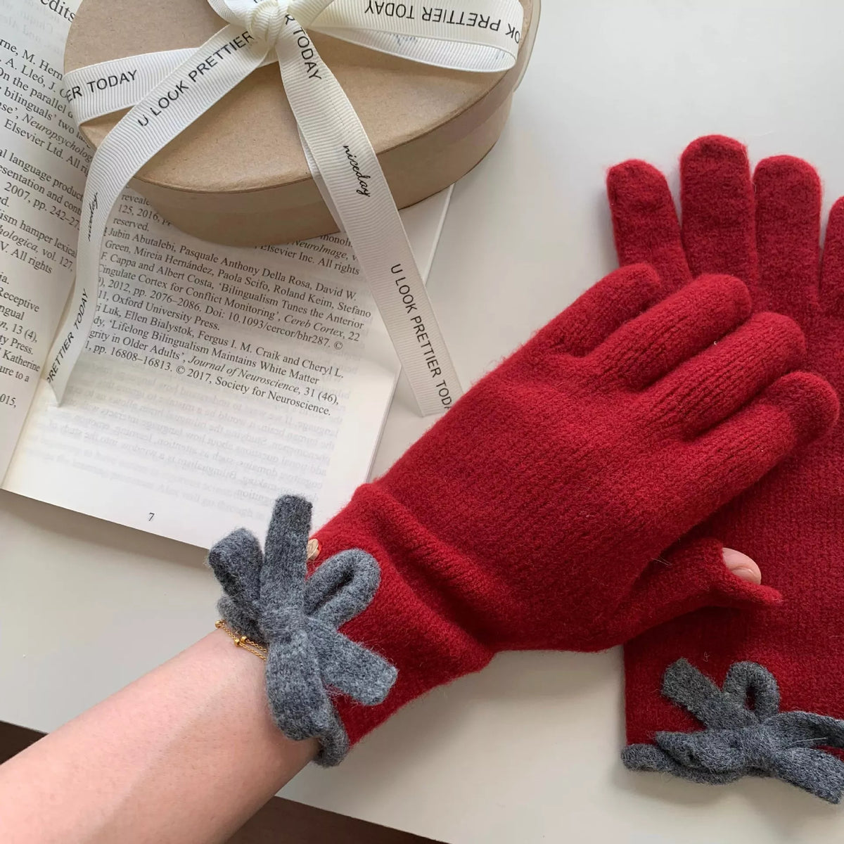 Knitted gloves with bow decorations by Trendsi, featuring soft fabric and stylish design for winter warmth and fashion.