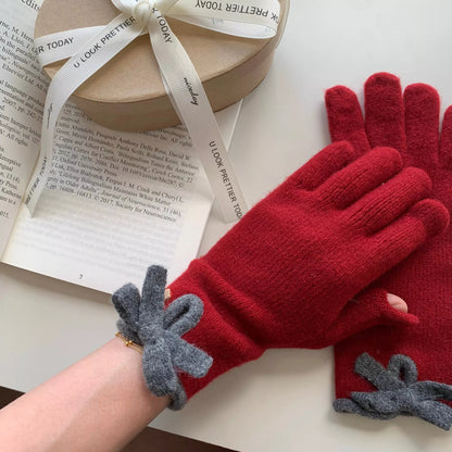 Knitted gloves with bow decorations by Trendsi, featuring soft fabric and stylish design for winter warmth and fashion.