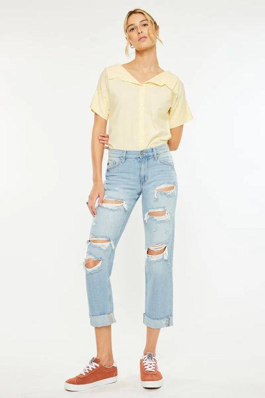 Light blue Kancan mid-rise distressed boyfriend jeans with rips and frayed hems, styled casually on a model.