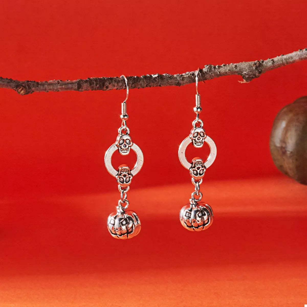 Halloween pumpkin dangle earrings by Trendsi featuring orange pumpkin charms on gold hooks.