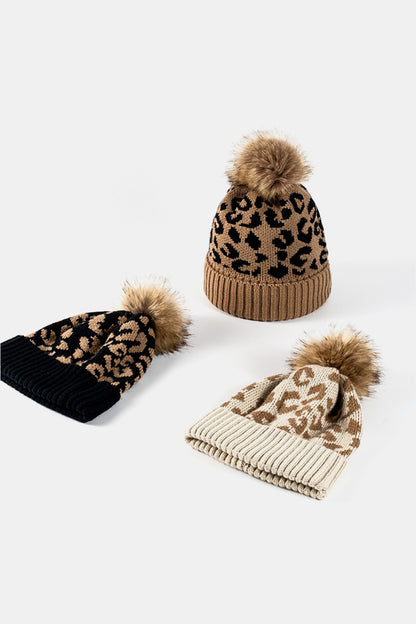 Leopard print pom-pom beanie with cuff, trendy knit hat from Trendsi featuring playful leopard pattern and cozy style.