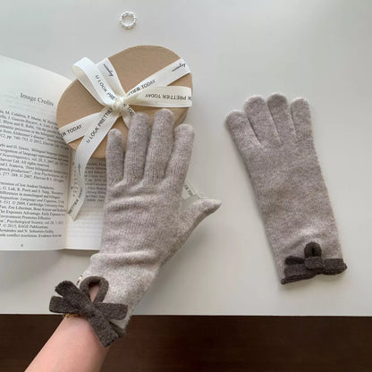 Knit gloves with bow decoration from Trendsi, featuring a cozy design and stylish bow detail on the cuffs.