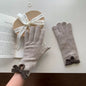 Knit gloves with bow decoration from Trendsi, featuring a cozy design and stylish bow detail on the cuffs.