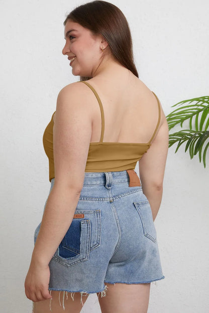 Plus size Basic Bae full size round neck slim cami by Trendsi, featuring a close-up of the black sleeveless top on a mannequin.