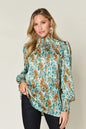 Printed smocked long sleeve blouse from Trendsi with a full size, featuring a stylish design and comfortable fit.