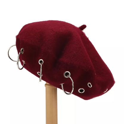 Metal ring embellished beret hat from Trendsi featuring a stylish, round design with metallic accents on soft fabric.