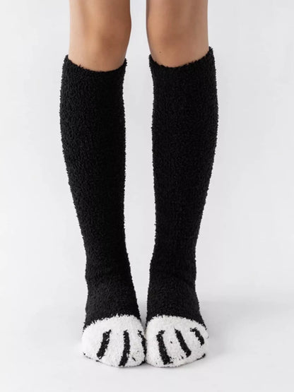 Fuzzy knee-high animal paw socks in soft material, featuring colorful paw print design, perfect for cozy wear.
